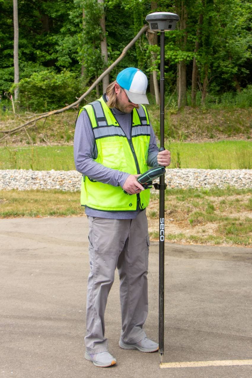 Técnico de campo usando un receptor GNSS para georreferenciar un punto en el bosque